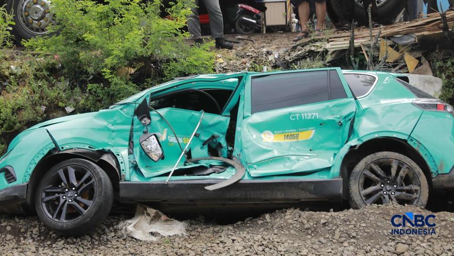 Kereta Krl melintas disamping taksi Green SM yang tertabrak KRL di perlintasan kereta Jalan Ampera, Bekasi, Selasa (28/4/2026). (CNBC Indonesia/Muhammad Sabki)