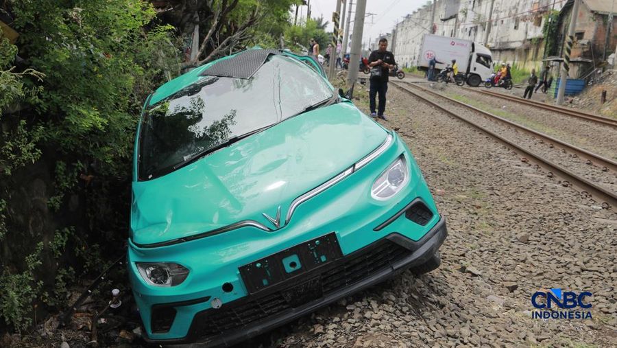 Kereta Krl melintas disamping taksi Green SM yang tertabrak KRL di perlintasan kereta Jalan Ampera, Bekasi, Selasa (28/4/2026). (CNBC Indonesia/Muhammad Sabki)