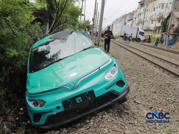 Kereta Krl melintas disamping taksi Green SM yang tertabrak KRL di perlintasan kereta Jalan Ampera, Bekasi, Selasa (28/4/2026). (CNBC Indonesia/Muhammad Sabki)
