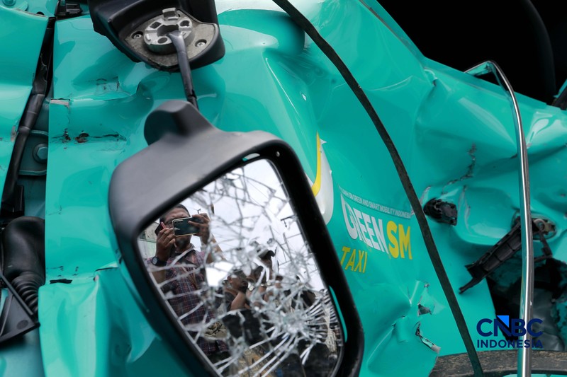 Kereta Krl melintas disamping taksi Green SM yang tertabrak KRL di perlintasan kereta Jalan Ampera, Bekasi, Selasa (28/4/2026). (CNBC Indonesia/Muhammad Sabki)