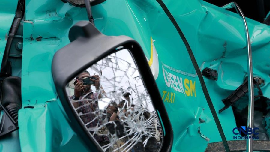 Kereta Krl melintas disamping taksi Green SM yang tertabrak KRL di perlintasan kereta Jalan Ampera, Bekasi, Selasa (28/4/2026). (CNBC Indonesia/Muhammad Sabki)