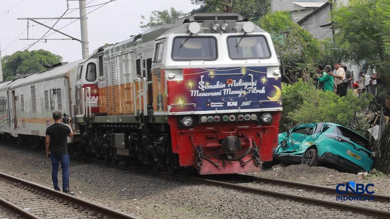 Kereta Krl melintas disamping taksi Green SM yang tertabrak KRL di perlintasan kereta Jalan Ampera, Bekasi, Selasa (28/4/2026). (CNBC Indonesia/Muhammad Sabki)
