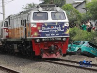 Kereta Krl melintas disamping taksi Green SM yang tertabrak KRL di perlintasan kereta Jalan Ampera, Bekasi, Selasa (28/4/2026). (CNBC Indonesia/Muhammad Sabki)