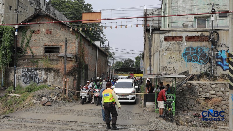 Warga melintasi perlintasan kereta Jalan Ampera, Bekasi, Selasa (28/4/2026). (CNBC Indonesia/Muhammad Sabki)