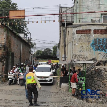 Warga melintasi perlintasan kereta Jalan Ampera, Bekasi, Selasa (28/4/2026). (CNBC Indonesia/Muhammad Sabki)