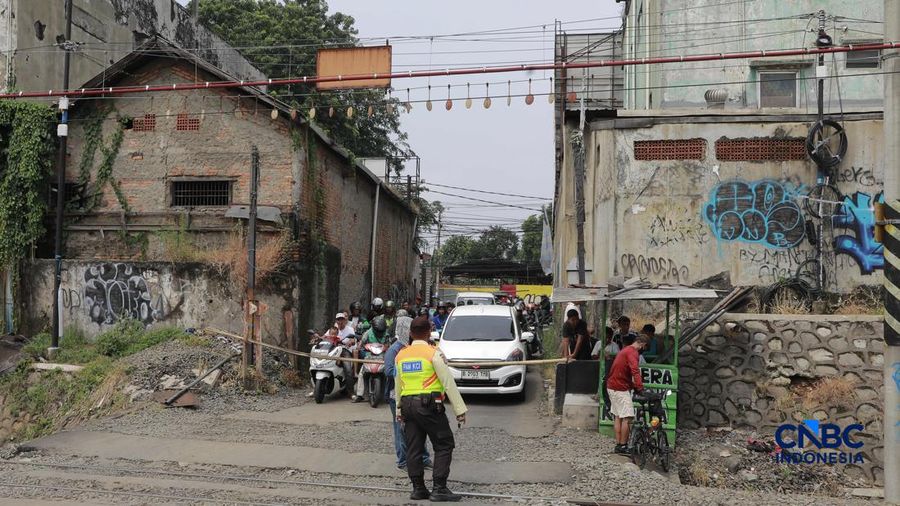 Warga melintasi perlintasan kereta Jalan Ampera, Bekasi, Selasa (28/4/2026). (CNBC Indonesia/Muhammad Sabki)