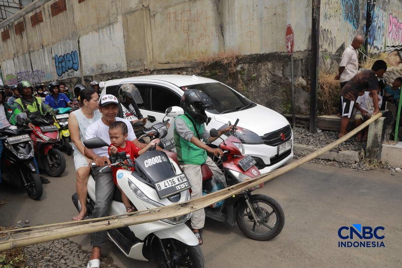 Warga melintasi perlintasan kereta Jalan Ampera, Bekasi, Selasa (28/4/2026). (CNBC Indonesia/Muhammad Sabki)