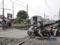 Warga melintasi perlintasan kereta Jalan Ampera, Bekasi, Selasa (28/4/2026). (CNBC Indonesia/Muhammad Sabki)