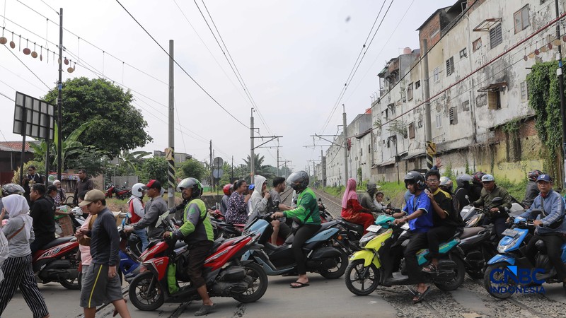 Warga melintasi perlintasan kereta Jalan Ampera, Bekasi, Selasa (28/4/2026). (CNBC Indonesia/Muhammad Sabki)