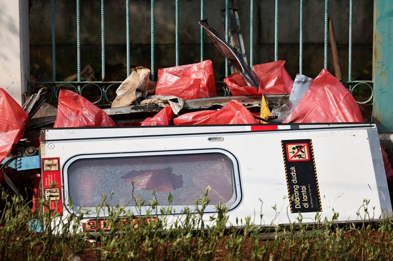 Puing-puing gerbong kereta komuter yang tertutup kain tergeletak di tanah di lokasi kejadian setelah tabrakan fatal antara kereta komuter dan kereta jarak jauh pada hari Senin, di Bekasi, pinggiran Jakarta, Indonesia, 29 April 2026. (REUTERS/Willy Kurniawan)