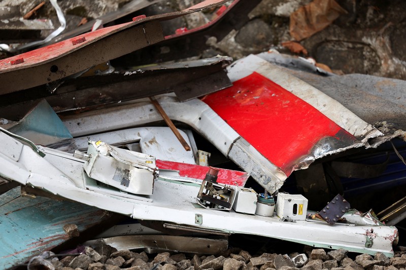 Puing-puing gerbong kereta komuter yang tertutup kain tergeletak di tanah di lokasi kejadian setelah tabrakan fatal antara kereta komuter dan kereta jarak jauh pada hari Senin, di Bekasi, pinggiran Jakarta, Indonesia, 29 April 2026. (REUTERS/Willy Kurniawan)