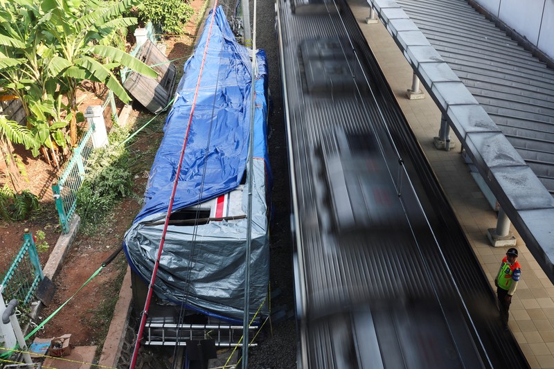 Puing-puing gerbong kereta komuter yang tertutup kain tergeletak di tanah di lokasi kejadian setelah tabrakan fatal antara kereta komuter dan kereta jarak jauh pada hari Senin, di Bekasi, pinggiran Jakarta, Indonesia, 29 April 2026. (REUTERS/Willy Kurniawan)