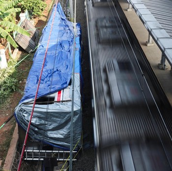 Puing-puing gerbong kereta komuter yang tertutup kain tergeletak di tanah di lokasi kejadian setelah tabrakan fatal antara kereta komuter dan kereta jarak jauh pada hari Senin, di Bekasi, pinggiran Jakarta, Indonesia, 29 April 2026. (REUTERS/Willy Ku