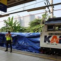 Seorang petugas keamanan berdiri di dekat puing-puing gerbong kereta komuter yang tertutup, tergeletak di lokasi setelah tabrakan fatal antara kereta komuter dan kereta jarak jauh pada hari Senin, di Bekasi, pinggiran Jakarta, Indonesia, 29 April 202