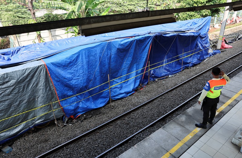 Puing-puing gerbong kereta komuter yang tertutup kain tergeletak di tanah di lokasi kejadian setelah tabrakan fatal antara kereta komuter dan kereta jarak jauh pada hari Senin, di Bekasi, pinggiran Jakarta, Indonesia, 29 April 2026. (REUTERS/Willy Kurniawan)