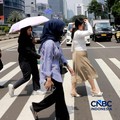 Warga berjalan dengan menutup kepala untuk berlindung dari terik matahari di Sudirman, Jakarta, Rabu (29/4/2026). (CNBC Indonesia/Muhammad Sabki)