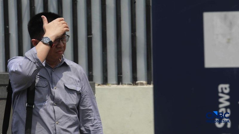 Warga berjalan dengan menutup kepala untuk berlindung dari terik matahari di Sudirman, Jakarta, Rabu (29/4/2026).