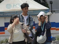 Warga berjalan dengan menutup kepala untuk berlindung dari terik matahari di Sudirman, Jakarta, Rabu (29/4/2026). (CNBC Indonesia/Muhammad Sabki)