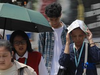 Warga berjalan dengan menutup kepala untuk berlindung dari terik matahari di Sudirman, Jakarta, Rabu (29/4/2026). (CNBC Indonesia/Muhammad Sabki)