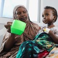 Seorang perempuan Somalia yang mengungsi di dalam negeri memberi makan anaknya yang kekurangan gizi di rumah sakit Daynile karena kekurangan makanan terapeutik yang menyelamatkan nyawa akibat gangguan pengiriman karena perang Iran telah memaksa klini