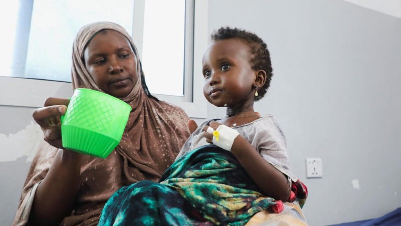 Seorang perempuan Somalia yang mengungsi di dalam negeri memberi makan anaknya yang kekurangan gizi di rumah sakit Daynile karena kekurangan makanan terapeutik yang menyelamatkan nyawa akibat gangguan pengiriman karena perang Iran telah memaksa klini