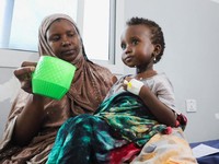 Seorang perempuan Somalia yang mengungsi di dalam negeri memberi makan anaknya yang kekurangan gizi di rumah sakit Daynile karena kekurangan makanan terapeutik yang menyelamatkan nyawa akibat gangguan pengiriman karena perang Iran telah memaksa klini