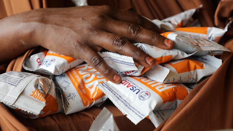 Seorang perempuan Somalia yang mengungsi di dalam negeri menerima bantuan makanan selama kunjungan Wakil Sekretaris Jenderal PBB untuk Urusan Kemanusiaan dan Koordinator Bantuan Darurat, Tom Fletcher (tidak terlihat dalam foto), karena kekurangan makanan terapeutik yang menyelamatkan nyawa akibat gangguan pengiriman karena perang Iran telah memaksa klinik yang merawat anak-anak yang kekurangan gizi parah untuk menolak pasien dan membatasi persediaan di Somalia yang dilanda kekeringan, di sebuah kamp di pinggiran Mogadishu, Somalia, 28 April 2026.