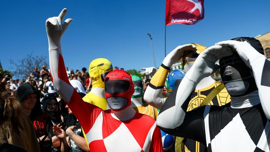 Orang-orang mengenakan kostum Power Rangers saat mereka berpartisipasi dalam demonstrasi
