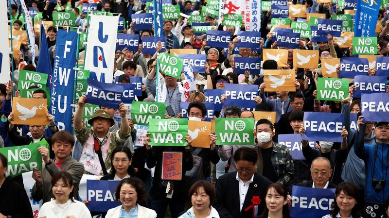 Para anggota Konfederasi Serikat Buruh Jepang, yang dikenal sebagai Rengo, mengangkat poster anti-perang selama unjuk rasa Hari Buruh tahunan mereka untuk menuntut upah yang lebih tinggi dan kondisi kerja yang lebih baik di Taman Yoyog, Tokyo Jepang (29/4/2026). (REUTERS/Issei Kato)