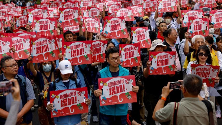 Para pekerja Taiwan dan asing menampilkan berbagai poster dan meneriakkan slogan-slogan saat mereka berbaris dalam pawai Hari Buruh Internasional di Taipei, Taiwan, Jumat (1/5/2026). (REUTERS/Ann Wang)