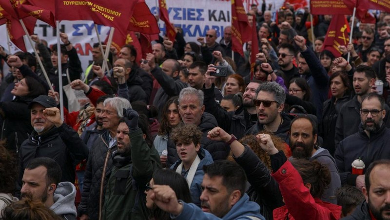 Para pendukung serikat pekerja PAME yang berafiliasi dengan komunis mengangkat tinju mereka dan menyanyikan "The Internationale" selama unjuk rasa memperingati Hari Buruh di Athena, Yunani, Jumat (1/5/2026). (REUTERS/Penny Karachaliou)