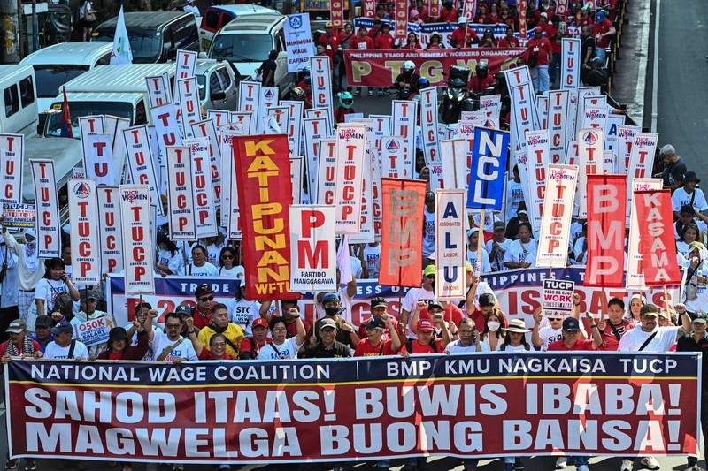 Para pengunjuk rasa berbaris sambil membawa spanduk tuntutan mereka selama demonstrasi Hari Buruh di Manila, Filipina, Jumat (1/5/2026). (REUTERS/Noel Celis)