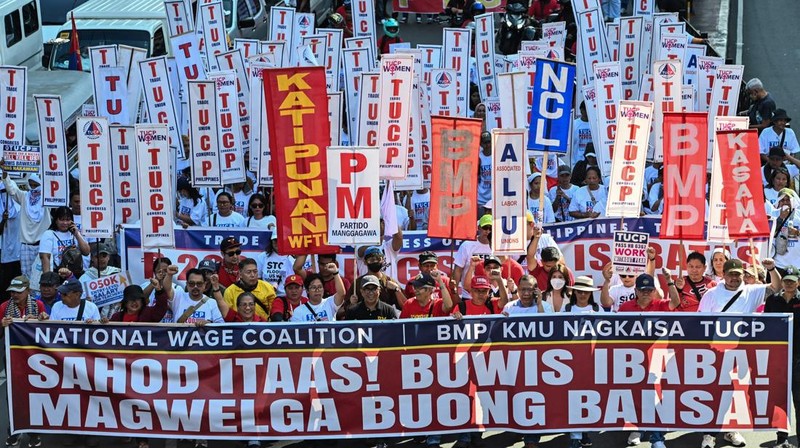 Para pengunjuk rasa berbaris sambil membawa spanduk tuntutan mereka selama demonstrasi Hari Buruh di Manila, Filipina, Jumat (1/5/2026). (REUTERS/Noel Celis)