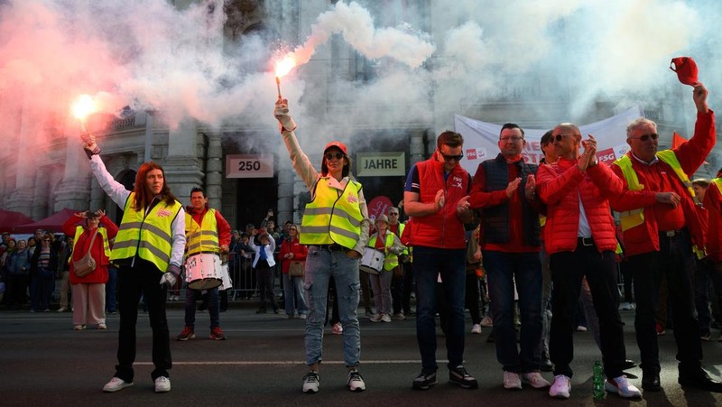 Sejumlah massa menyalakan suar atau flare saat menghadiri perayaan Hari Buruh tradisional di Wina, Austria, Jumat (1/5/2026). (REUTERS/Elisabeth Mandl)