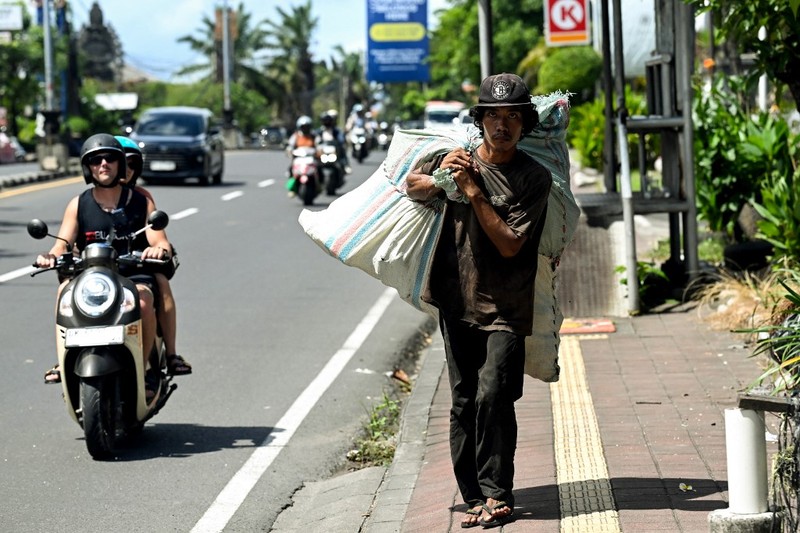 Sampah plastik terlihat berserakan di bawah pohon bakau di pusat konservasi bakau dekat Denpasar di pulau wisata Bali, pada 30 April 2026. (Photo by SONNY TUMBELAKA / AFP)