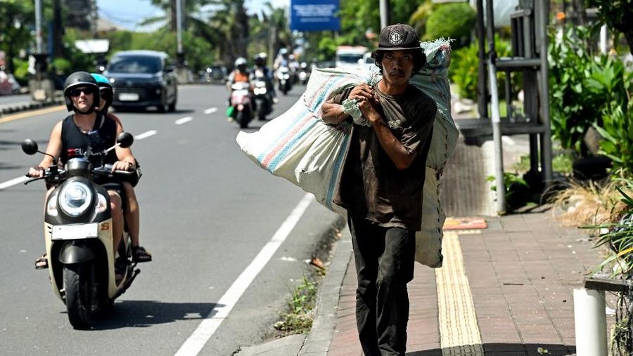 Seorang pemulung membawa sampah plastik dalam karung di Denpasar, pulau wisata Bali, pada 30 April 2026.