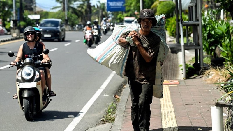 Seorang pemulung membawa sampah plastik dalam karung di Denpasar, pulau wisata Bali, pada 30 April 2026.