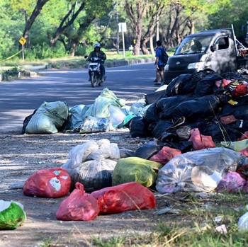 Tumpukan sampah terlihat di jalanan Denpasar, pulau wisata Bali, pada 24 April 2026. (Photo by SONNY TUMBELAKA / AFP)