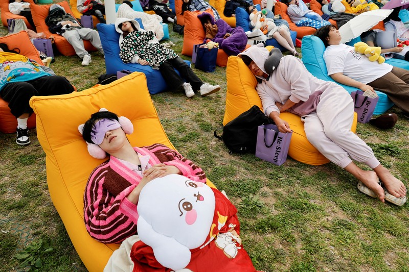 Para peserta tidur siang selama kontes Power Nap 2026 di taman Sungai Han, Seoul, Korea Selatan, Sabtu (2/5/2026). (REUTERS/Kim Soo-hyeon)