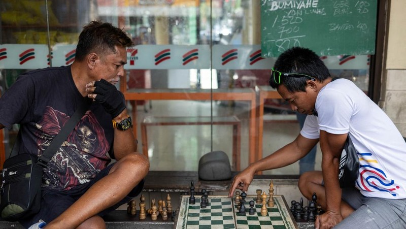 Para pengemudi becak bermain catur untuk mengisi waktu luang di Manila, Filipina, 4 Mei 2026.