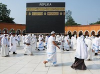 Umat Islam Indonesia berjalan di dekat replika Ka'bah saat melakukan Tawaf saat berlatih ibadah haji di Pusat Pelatihan Almahmudah Manasik, Tangsel, di Jakarta, Indonesia, 19 April 2026. (REUTERS/Ajeng Dinar Ulfiana)