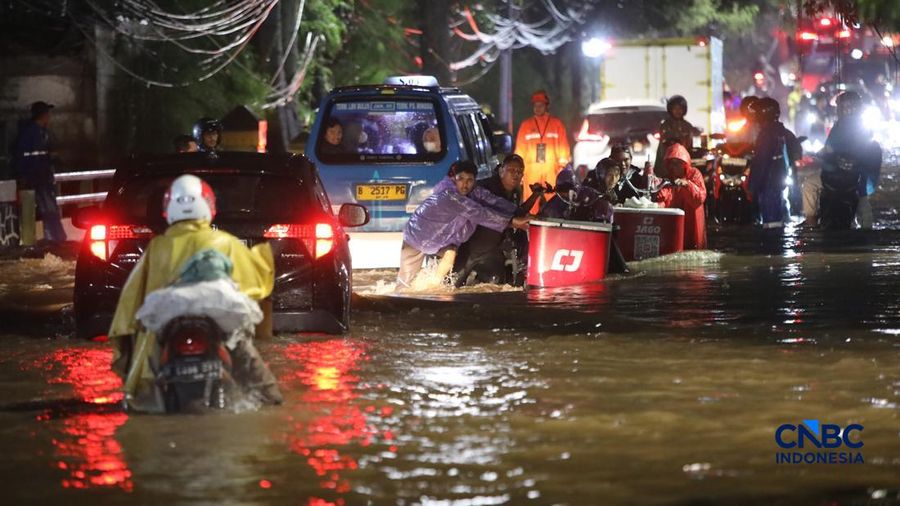 Warga menerobos banjir yang merendam ruas Jalan Benda Bawah, Cilandak Timur, Jakarta, Senin (4/5/2026).
