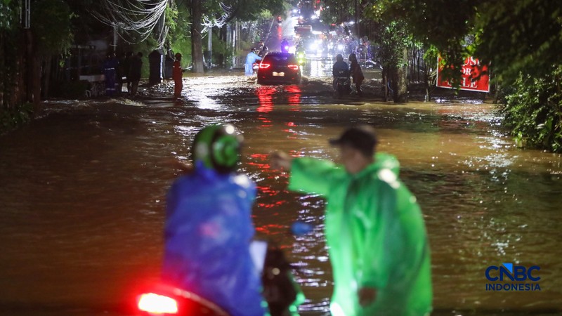 Warga menerobos banjir yang merendam ruas Jalan Benda Bawah, Cilandak Timur, Jakarta, Senin (4/5/2026). (CNBC Indonesia/Faisal Rahman)