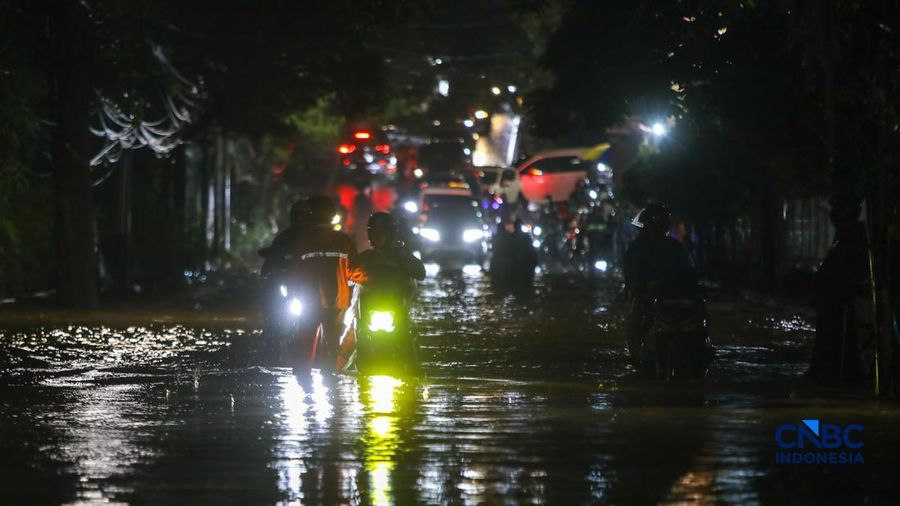 Warga menerobos banjir yang merendam ruas Jalan Benda Bawah, Cilandak Timur, Jakarta, Senin (4/5/2026). (CNBC Indonesia/Faisal Rahman)