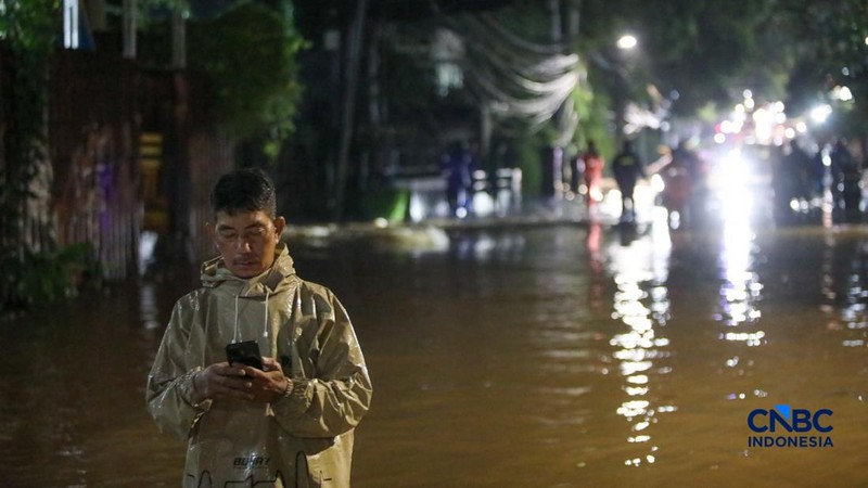Warga menerobos banjir yang merendam ruas Jalan Benda Bawah, Cilandak Timur, Jakarta, Senin (4/5/2026).