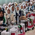 Indonesian pilgrims wait before departing for the holy city of Mecca to perform the annual Hajj, at Juanda International Airport in Sidoarjo on April 22, 2026. (Photo by JUNI KRISWANTO / AFP)