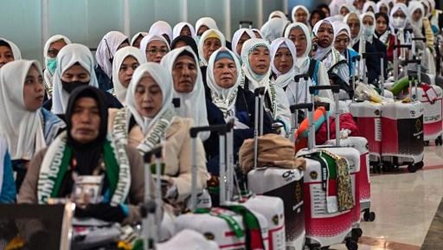 Indonesian pilgrims wait before departing for the holy city of Mecca to perform the annual Hajj, at Juanda International Airport in Sidoarjo on April 22, 2026. (Photo by JUNI KRISWANTO / AFP)