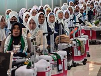 Indonesian pilgrims wait before departing for the holy city of Mecca to perform the annual Hajj, at Juanda International Airport in Sidoarjo on April 22, 2026. (Photo by JUNI KRISWANTO / AFP)