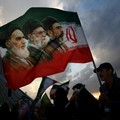 FILE PHOTO: A man holds a flag with a picture of late leader of the Islamic Revolution Ayatollah Ruhollah Khomeini, late Supreme Leader of Iran Ayatollah Ali Khamenei and Iran's new Supreme Leader Mojtaba Khamenei, during a rally in Tehran, Iran, Apr