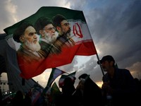 FILE PHOTO: A man holds a flag with a picture of late leader of the Islamic Revolution Ayatollah Ruhollah Khomeini, late Supreme Leader of Iran Ayatollah Ali Khamenei and Iran's new Supreme Leader Mojtaba Khamenei, during a rally in Tehran, Iran, Apr